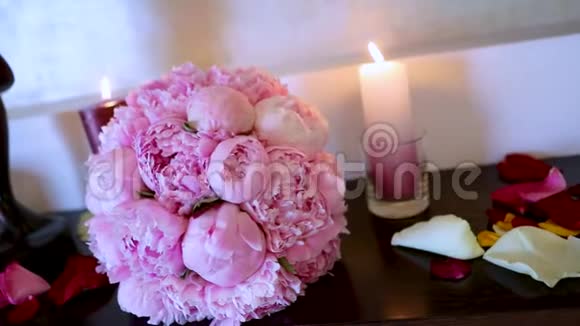 婚礼花束放在桌子上燃烧蜡烛和新娘花束视频的预览图