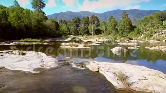 热带景观的岩石上的绿色河流溪流视频的预览图