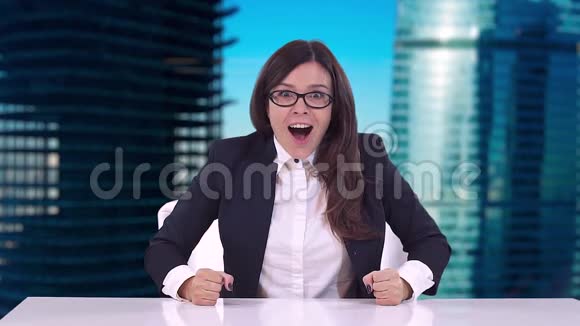 商务女性穿着商务套装坐在办公桌后面享受着一笔不错的交易视频的预览图