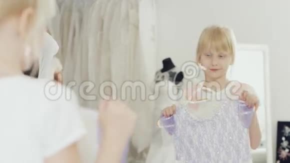 6岁的年轻女士在镜子前试穿一件优雅的衣服视频的预览图