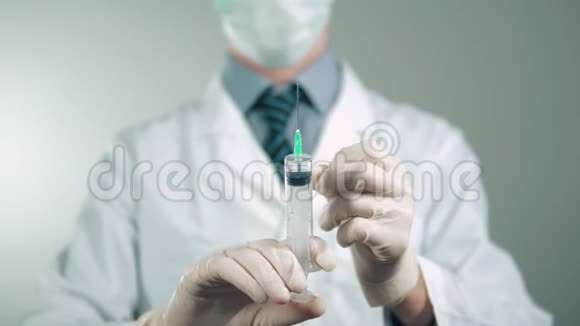 医生手里拿着一支注射器手套里拿着药脸上有防护面罩保健视频的预览图