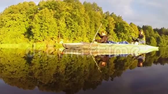 男人和女人在美丽的河上同时划独木舟视频的预览图