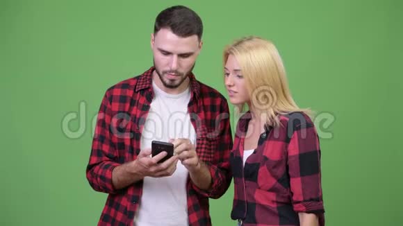 年轻的幸福夫妇一起用电话得到好消息视频的预览图
