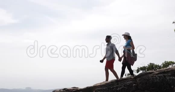一对从山顶看风景的游客年轻男女旅行者视频的预览图