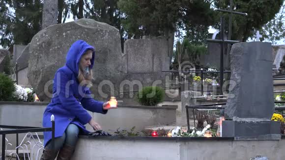 秋天妇女在墓地上点燃蜡烛4K视频的预览图