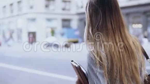 年轻的女商人穿过美国纽约的市中心拿着文件和文件夹视频的预览图