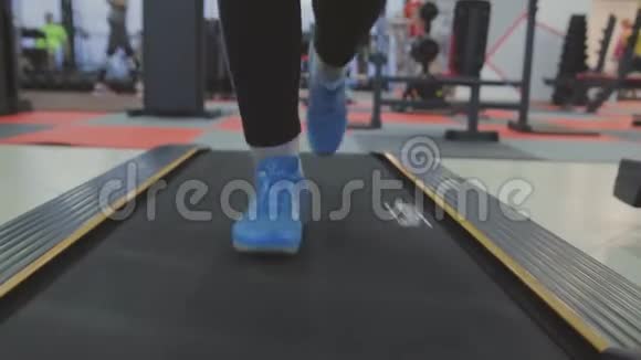 一个女人在健身俱乐部的跑步机上训练视频的预览图