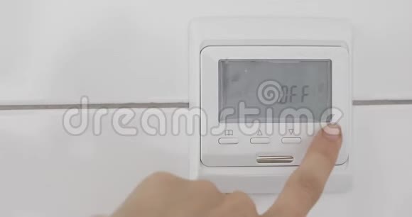 女性在白色墙壁上的温度传感器上的手视频的预览图