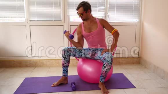 一个穿着粉红色T恤和蓝色紧身裤的顽皮帅哥正在从事一个女孩的健身活动慢动作视频的预览图