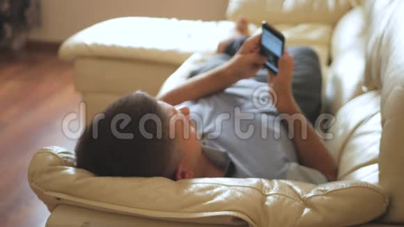 男人在家里沙发上用手机视频的预览图