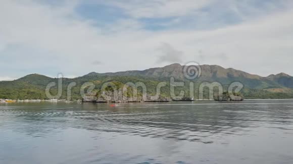 从移动的渡船上看到布桑加山脉巴拉望群岛的热带景观孤独的小船视频的预览图