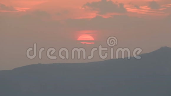橙色的太阳盘躲在云层后面用温暖的晚霞照亮天空视频的预览图