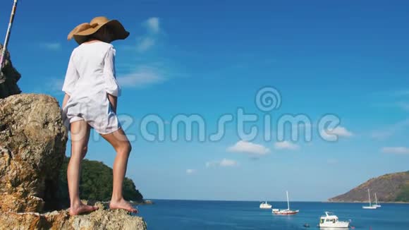 一个戴帽子的孤独女孩正沿着岛屿海岸线散步日出时热带天堂海滩视频的预览图