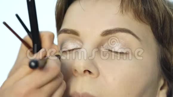 专业化妆师在眼睑上涂眼线的特写时尚界化妆品视频的预览图