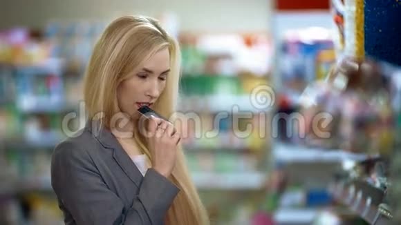 带着信用卡微笑的年轻休闲女士在超市购物时犹豫不决视频的预览图