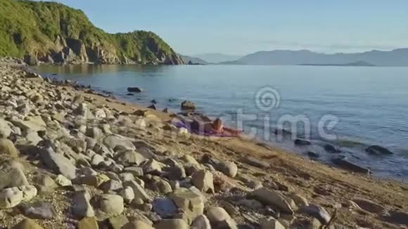 躺在瑜伽姿势中的少女躺在闪亮的海面上视频的预览图