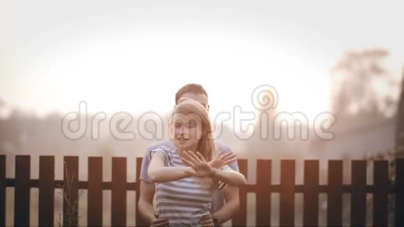 年轻的幸福夫妇站在后院一起玩开朗的男人和女人在外面跳舞视频的预览图
