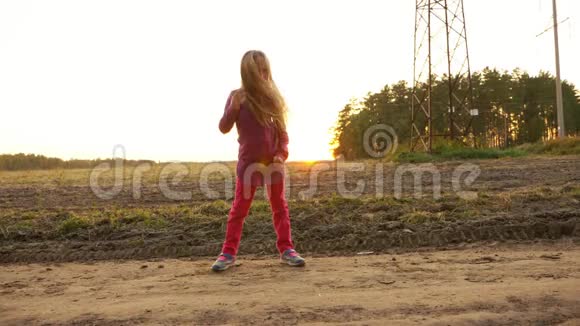 年轻的白种人女孩在户外跳舞唱歌在田野的田园风光中漫步秋日手持视频的预览图