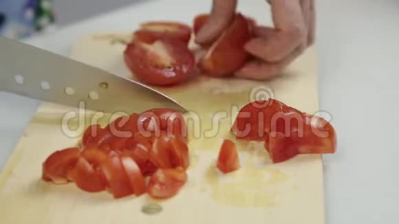 妇女使用菜刀滑切新鲜番茄在木切割板莴苣或披萨用番茄切片视频的预览图