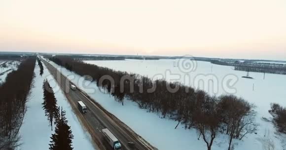 在冬季道路上行驶的卡车和汽车的空中景观4K视频的预览图