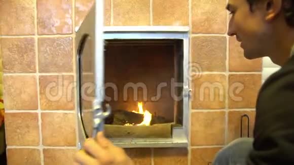 人们在温暖的炉火旁放松双手热身在城外的房子里打开舒适的壁炉视频的预览图