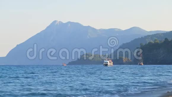 小型旅游船沿海岸漂浮海浪日落土耳其南部海岸视频的预览图