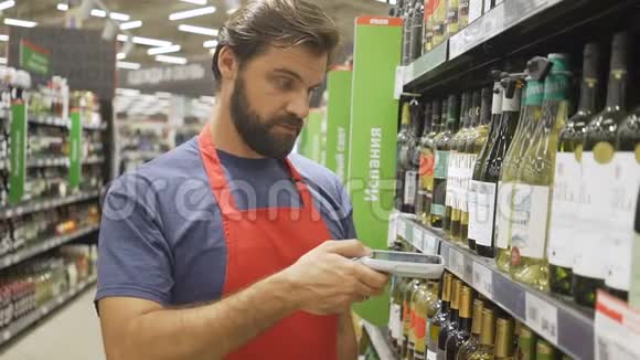 超市员工在超市的葡萄酒区用红色扫描条码视频的预览图