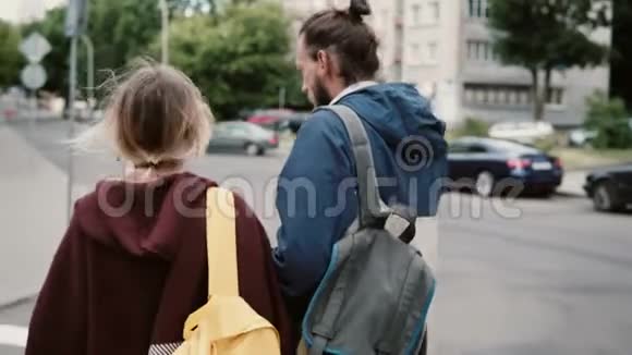年轻的游客夫妇在市中心散步交谈吃快餐的人带背包的嬉皮士女人视频的预览图