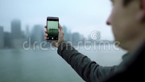 年轻游客用智能手机拍摄曼哈顿岛视频的预览图