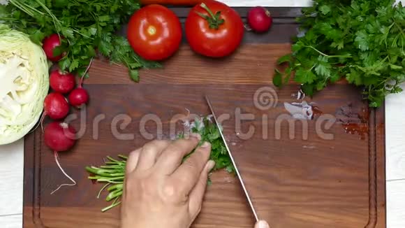 用刀子在切割板上切欧芹和蔬菜视频的预览图