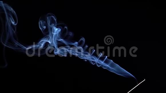 在黑色的背景上用烟雾把燃烧的香棒关上慢动作视频的预览图