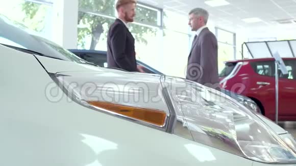 汽车展厅买家和销售经理握手视频的预览图