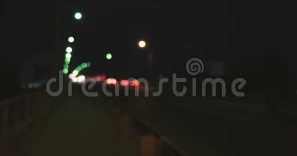 在高峰时段接近高速公路的前照灯和尾灯散焦繁忙立交桥的夜景视频的预览图