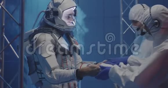 科学家帮助宇航员戴上手套视频的预览图