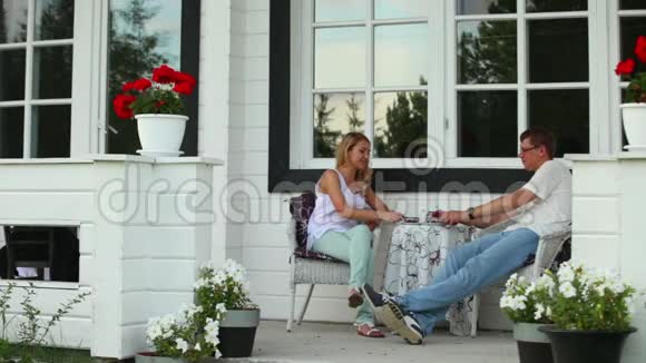 一对夫妇正在一间避暑别墅的后院喝茶视频的预览图