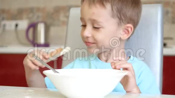 孩子坐在厨房的桌子旁吃面包和汤健康宝宝食品的概念视频的预览图