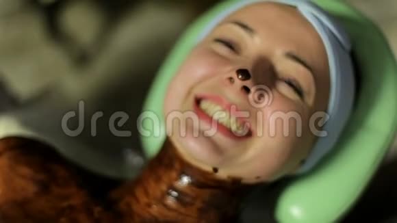 一个女孩在水疗中心享受巧克力按摩特写视频的预览图