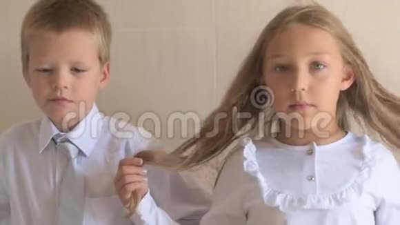 穿着校服的蓝眼睛和金发的快乐孩子的特写肖像男孩和女孩的学龄前儿童视频的预览图