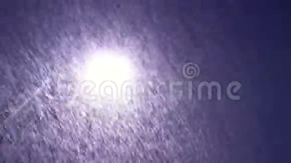 城市街道上大雪纷飞的空中景观照明的公共灯手持摄像机视频的预览图