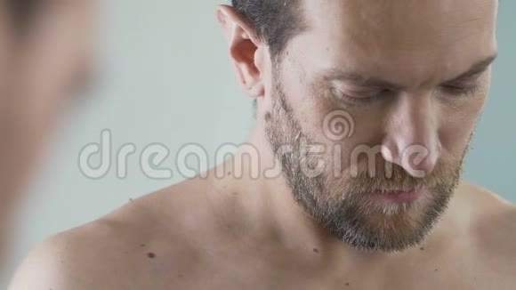 男人在面部皮肤皮肤和卫生上涂上剃须泡沫早晨仪式视频的预览图