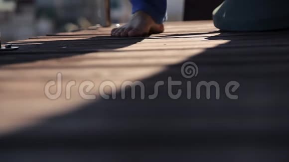 一个女孩走在木制露台的地板上视频的预览图