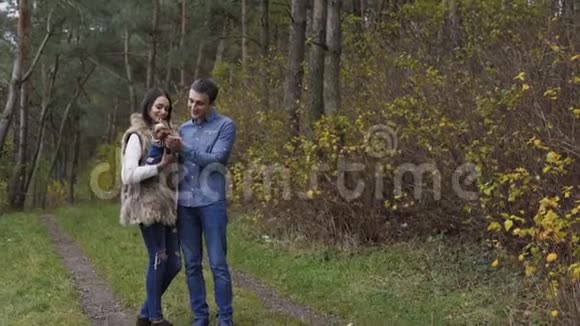可爱的夫妇在森林里和他们的宠物狗玩得很开心4K视频的预览图