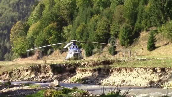 直升机降落在一片森林的草地上视频的预览图