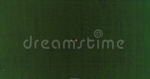 空中飞行运动员在训练后休息躺在体育场的草坪上从上面可以看到运动服的年轻女孩视频的预览图