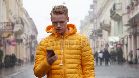 一个年轻人在欧洲的冬季大街上与电话交谈视频的预览图