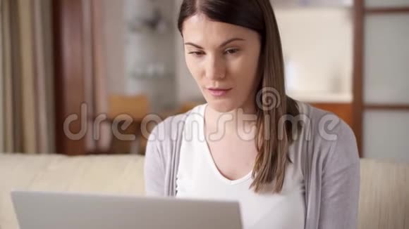 女商人在家里用笔记本电脑女商人听到好消息兴奋开心的微笑视频的预览图