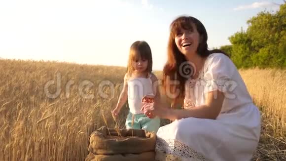快乐的农夫妈妈和小儿子女儿在田里玩耍妈妈和小孩在玩视频的预览图