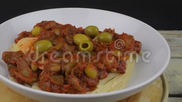 意大利面配番茄牛肉酱和绿色橄榄旋转射击4K决议视频的预览图