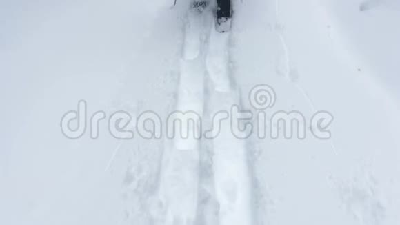 4一个穿雪鞋的人在白雪上行走的镜头视频的预览图