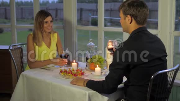 晚上快乐的一对情侣享受浪漫的晚餐戴上眼镜喝上葡萄酒视频的预览图